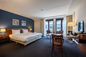 Executive kamer in Amrâth Grand Hotel Frans Hals met twee eenpersoonsbedden, twee schilderijen boven het bed, houten nachtkastjes en nachtlampjes