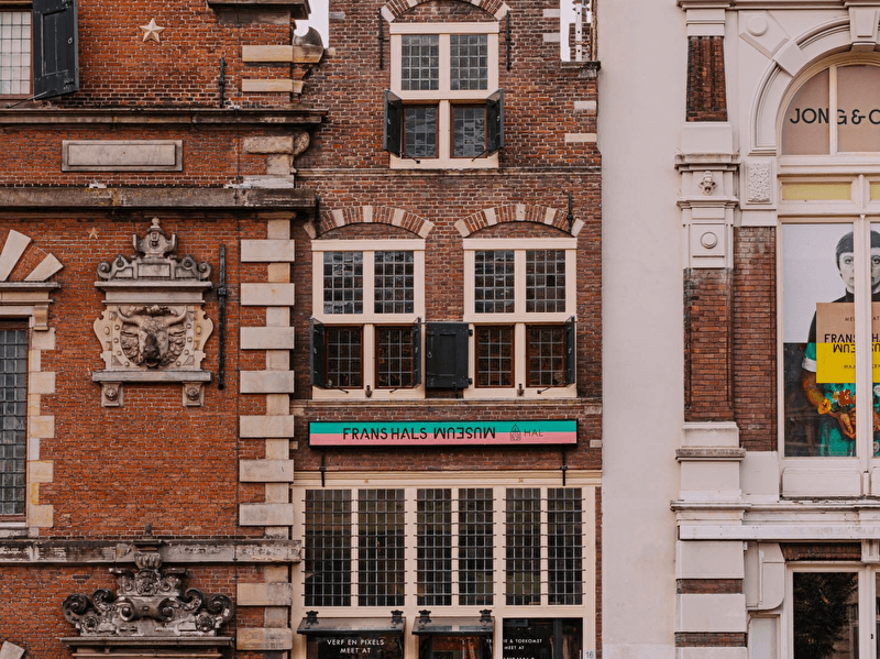 Vooraanzicht van de entree van Museum Haarlem met het opschrift “Frans Hals Museum – Hal”, bevestigd aan een historische gevel.