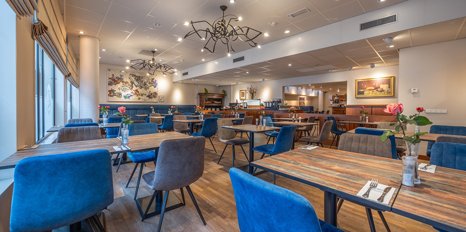 Restaurant im Amrath Grand Hotel Frans Hals mit schwarzen Holztischen und -stühlen in der Mitte des Raumes, mit viel Tageslicht.